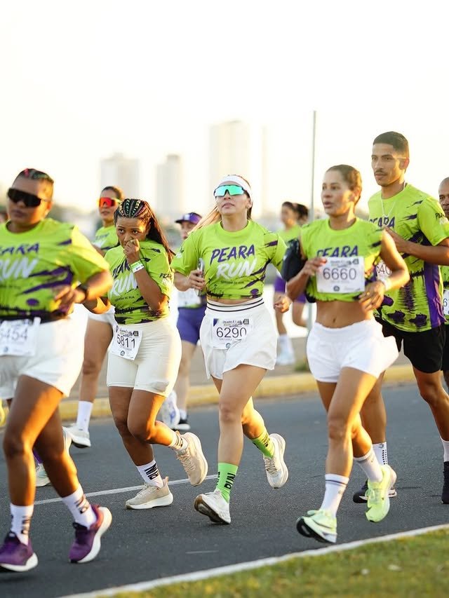 Grupo de corredores da Peara Run no percurso, com os prédios de Araguaína ao fundo