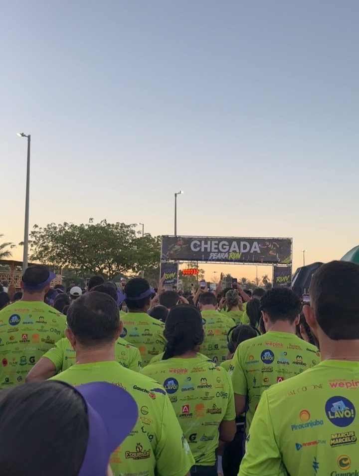 Público de costas no pórtico de chegada da Peara Run, com as marcas dos patrocinadores estampadas nas camisetas